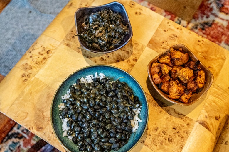 Three bowls of food sit on a wooden table.