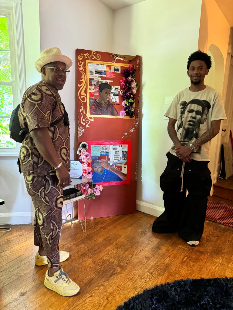 photo of two people standing in front of artwork. 
