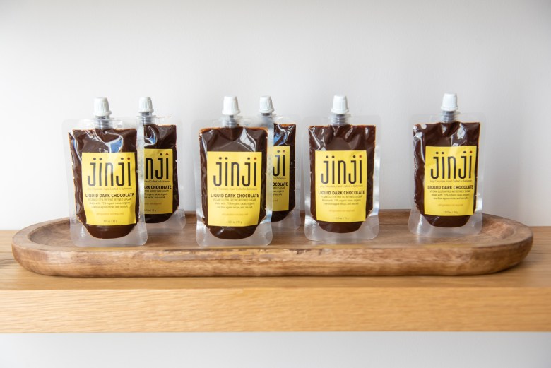 Photograph of a row of liquid dark chocolate. 