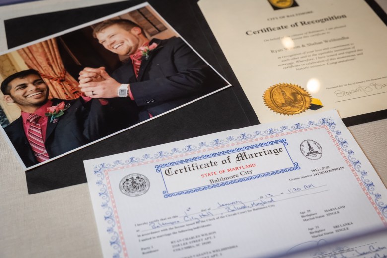 A marriage certificate from the first gay couple to be wed in Maryland. A photo of the couple smiling and holding hands, and a certificate of recognition. 