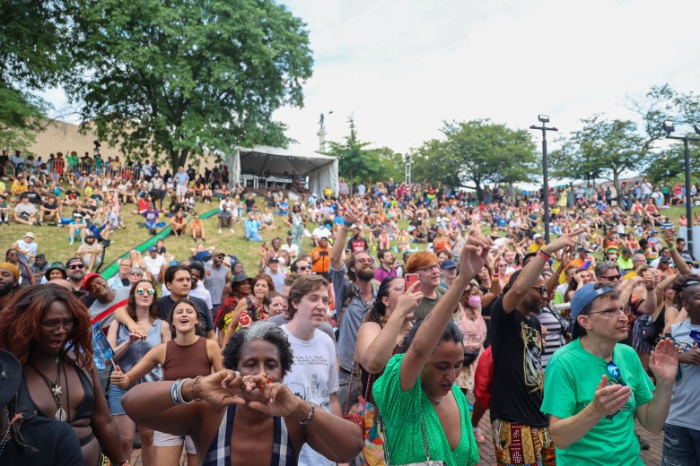 An enthusiastic crowd at the main stage watches a performance. 