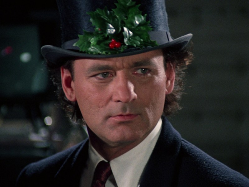 A man in a holiday hat. A still from the movie "Scrooged"