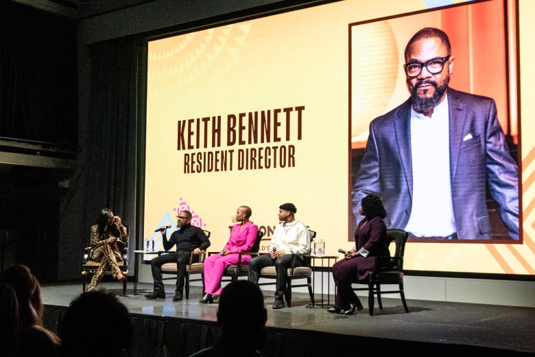 The cast of the lion king sits on stage during a moderated Q+A
