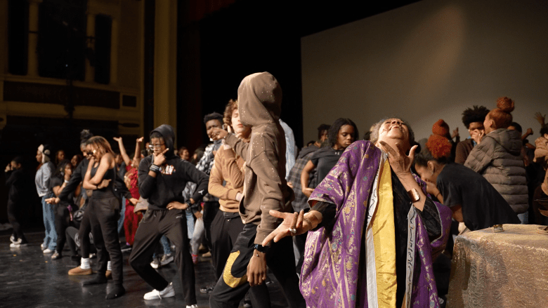 Maria at the Baltimore School for the Arts. Figures dance on stage. 